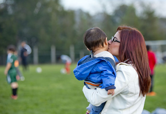 While helping partner Yasert Ortega with his job as a soccer instructor, Ortiz takes time out for a quick snuggle with Ezra. With Ortiz and her boyfriend, the support system works both ways. “She wants to go to school,” Ortega says. “And whatever she wants, she goes for it. I’m very proud of her.