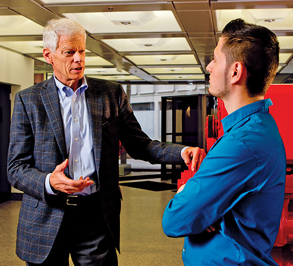 Mark Levett, chief executive officer of the Cummins Foundation, talks with budding engineer Uriel Lopez. Lopez, a graduate of the Columbus Signature Academy, is now enrolled in the Purdue Tech Mechanical Engineering Technology program and also works full time as an apprentice draftsman at Cummins Inc.