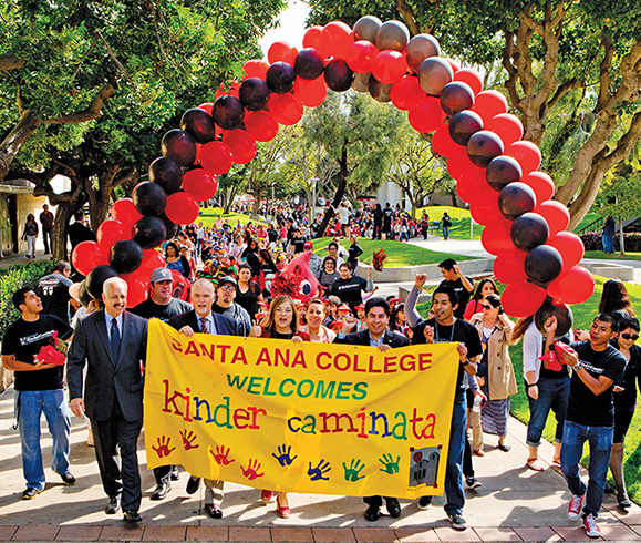 Holding the banner and leading the 2014 Kinder Caminata parade are (from left): Raúl Rodriguez, chancellor of the Rancho Santiago Community College District (RSCC); Rick Miller, superintendent of the Santa Ana Unified School District; U.S. Rep. Loretta Sanchez (D-Calif.); José Solorio, president of the RSCC board of trustees, and Jorge Sandoval, student government president at Santa Ana College.