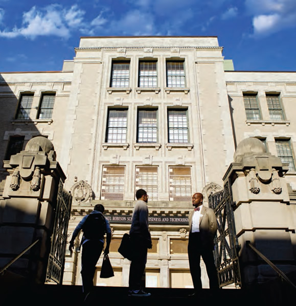 Victor John, P-TECH’s assistant principal for administration, chats with a student near the school’s entrance. P-TECH shares the impressive building, located in Brooklyn’s Crown Heights section, with two other secondary schools in the New York City system.